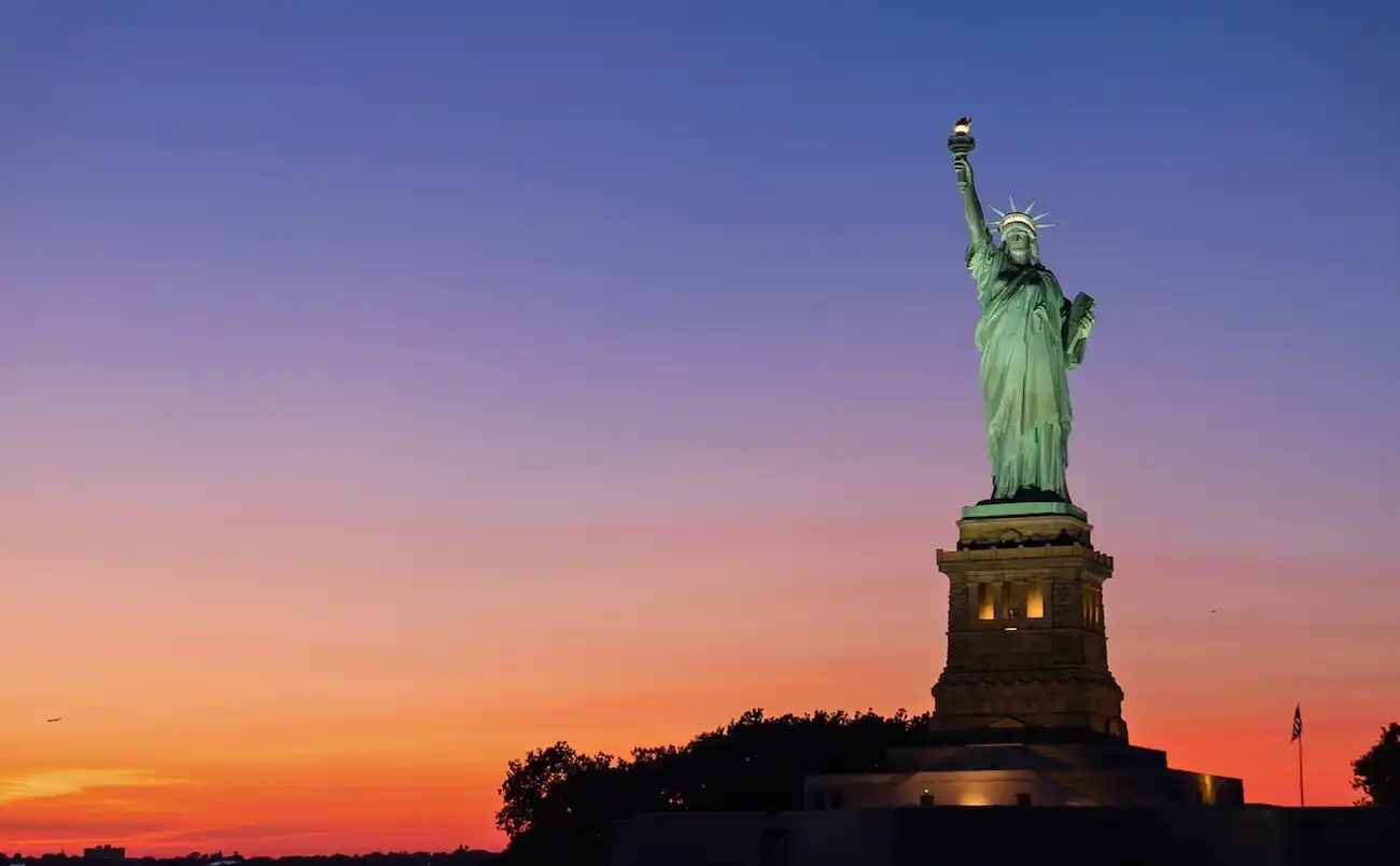 The Statue of Liberty, a symbol of freedom, standing tall against the backdrop of the New York City skyline.