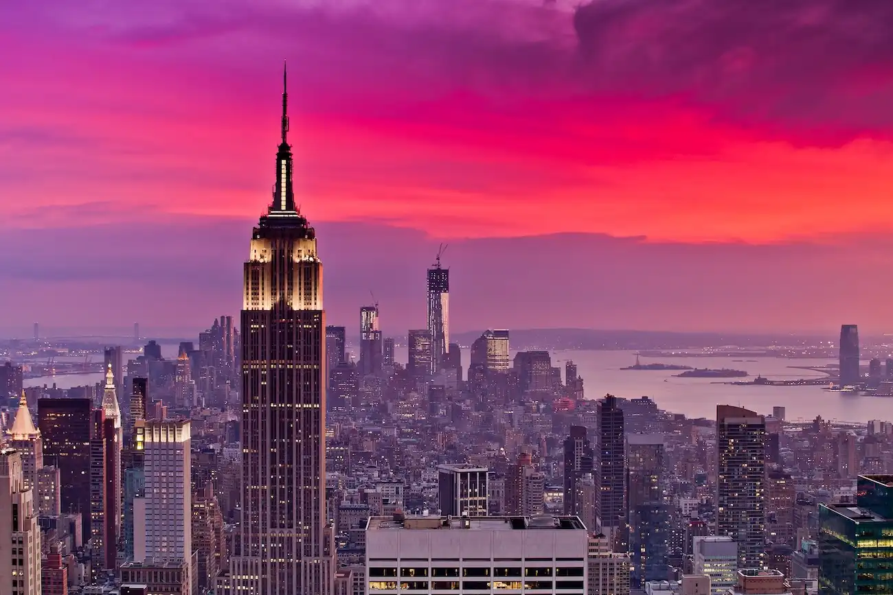 Dramatic view of the Empire State Building towering over the New York City skyline.
